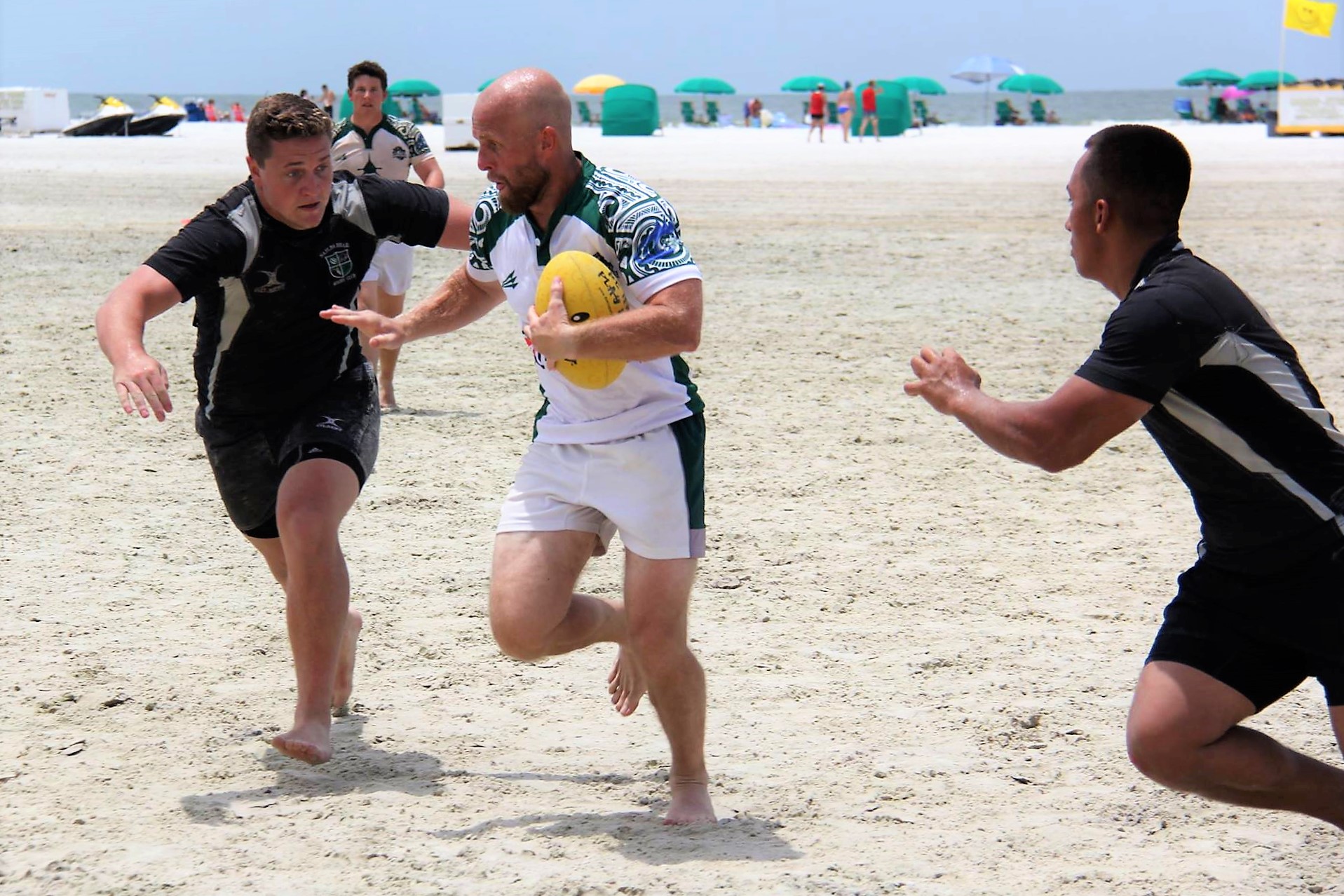 beerfoot-beach-rugby-stiffarm